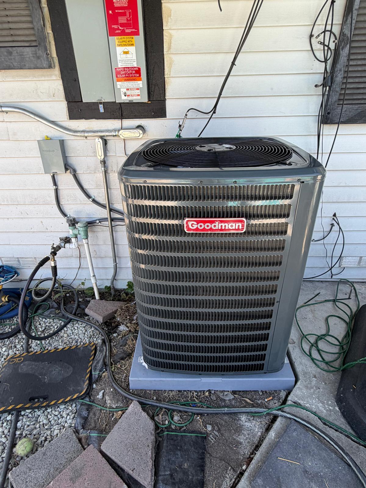 Newly installed Goodman air conditioning unit on concrete pad outside home in Brentwood CA